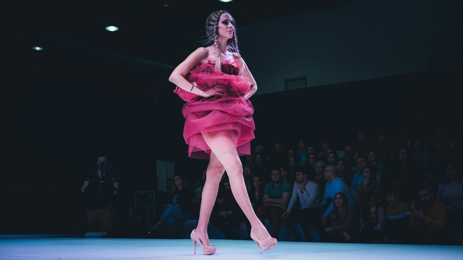 A front-row seat at a Fashion Week runway show, representing the growing crossover between the music and fashion industries