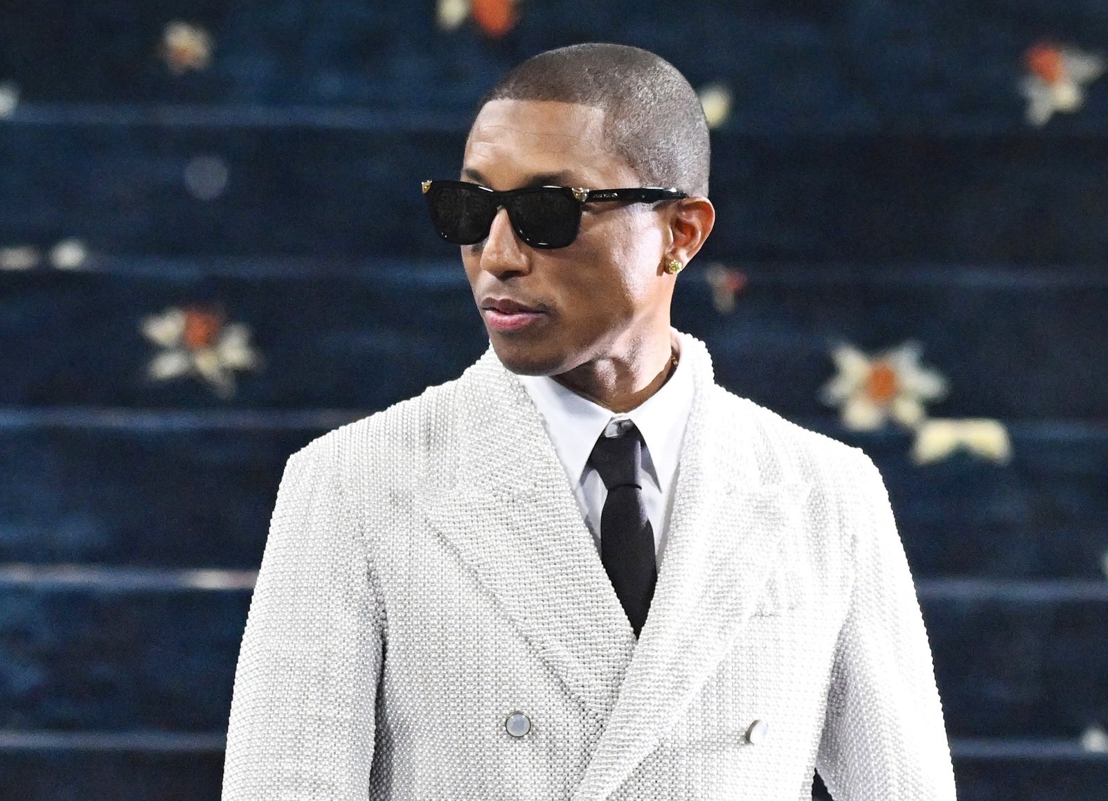 Pharrell Williams speaking during an interview, representing his views on crossing between music and fashion