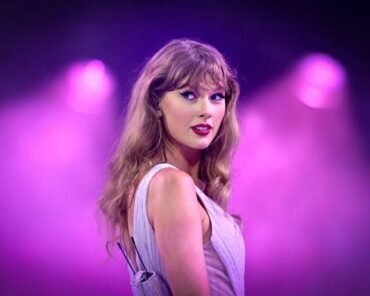 Taylor Swift performing on stage, representing her new original song for Toy Story 5