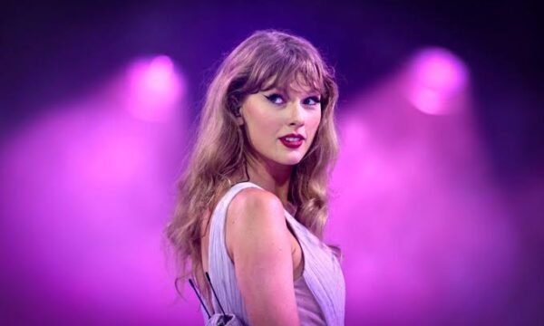 Taylor Swift performing on stage, representing her new original song for Toy Story 5
