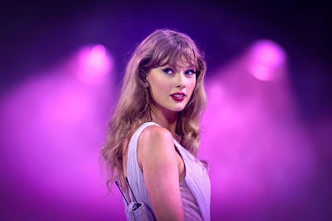 Taylor Swift performing on stage, representing her new original song for Toy Story 5