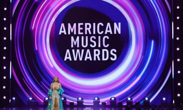 A host on stage at a major music awards show, representing some of the most memorable hosting moments in the genre's history
