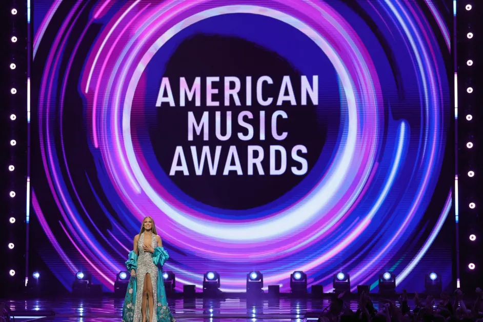 A host on stage at a major music awards show, representing some of the most memorable hosting moments in the genre's history