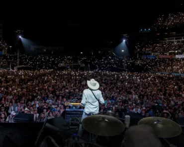 A sold-out arena crowd during a farewell concert tour, representing the emotional significance of these live music events