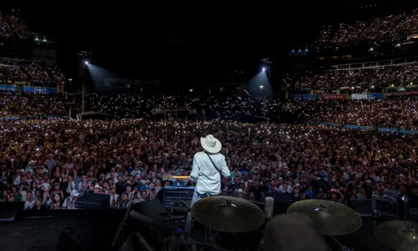 A sold-out arena crowd during a farewell concert tour, representing the emotional significance of these live music events