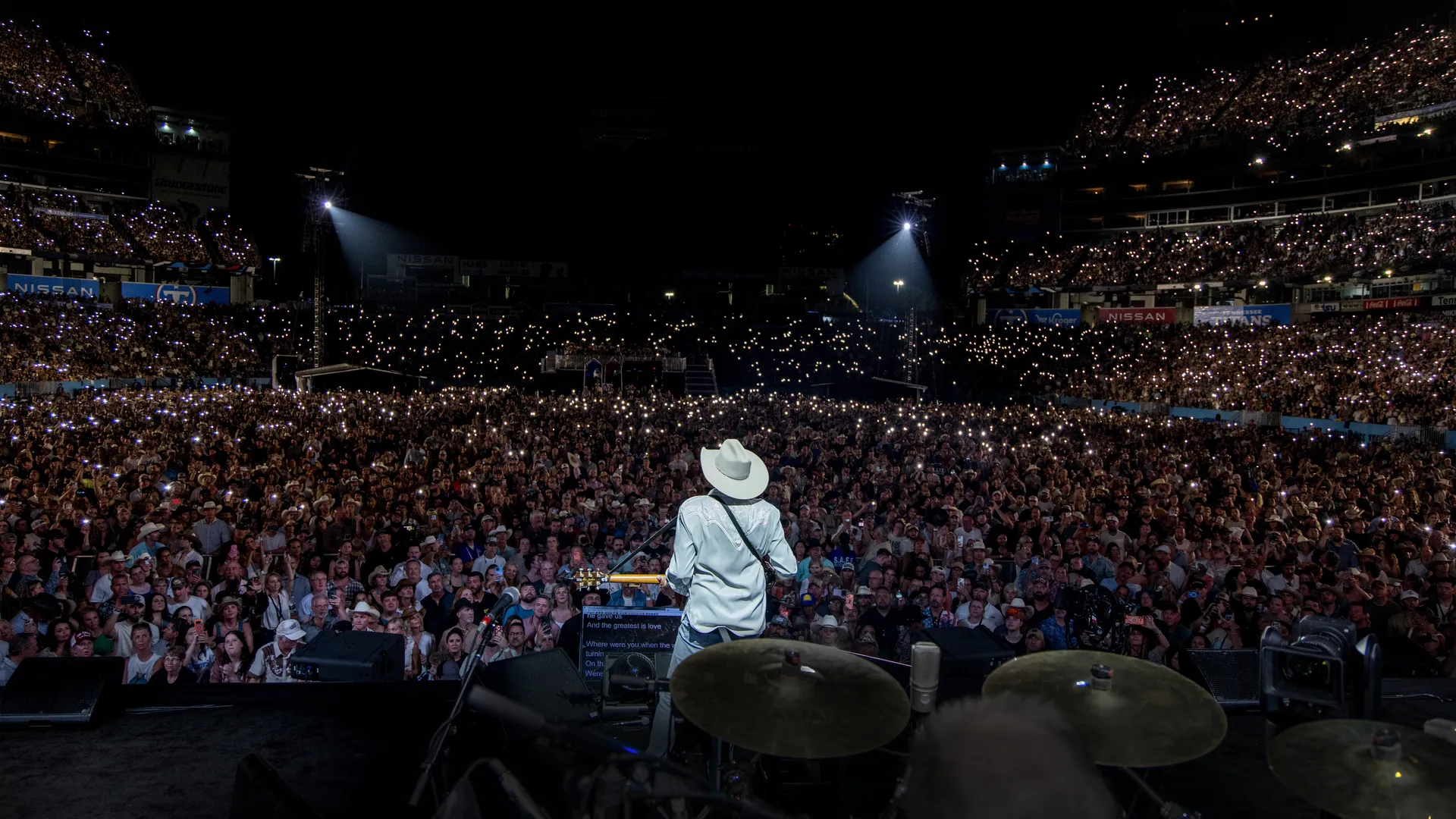 A sold-out arena crowd during a farewell concert tour, representing the emotional significance of these live music events