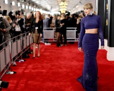 A musician arriving at a music awards show in a bold fashion look, representing the genre's memorable red carpet moments