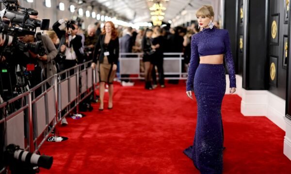 A musician arriving at a music awards show in a bold fashion look, representing the genre's memorable red carpet moments