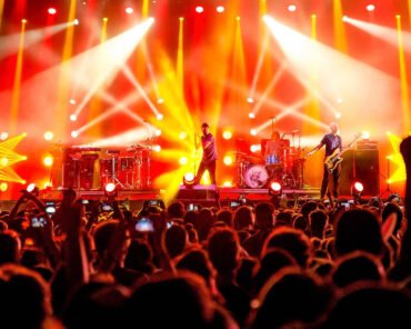 An opening act performing to a large concert crowd, representing artists whose careers outgrew their original headlining tour partner