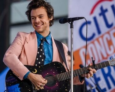 Harry Styles performing solo on stage, representing his transition from boy band member to solo pop icon