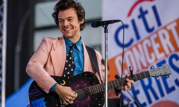 Harry Styles performing solo on stage, representing his transition from boy band member to solo pop icon