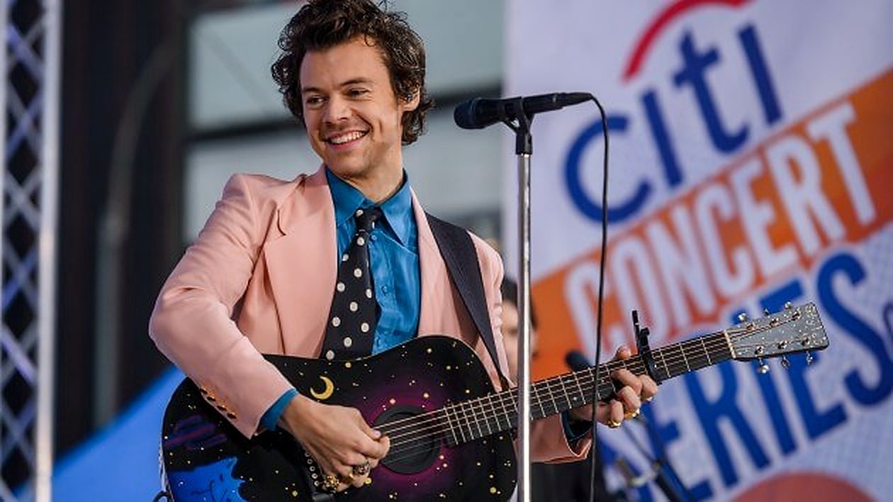 Harry Styles performing solo on stage, representing his transition from boy band member to solo pop icon