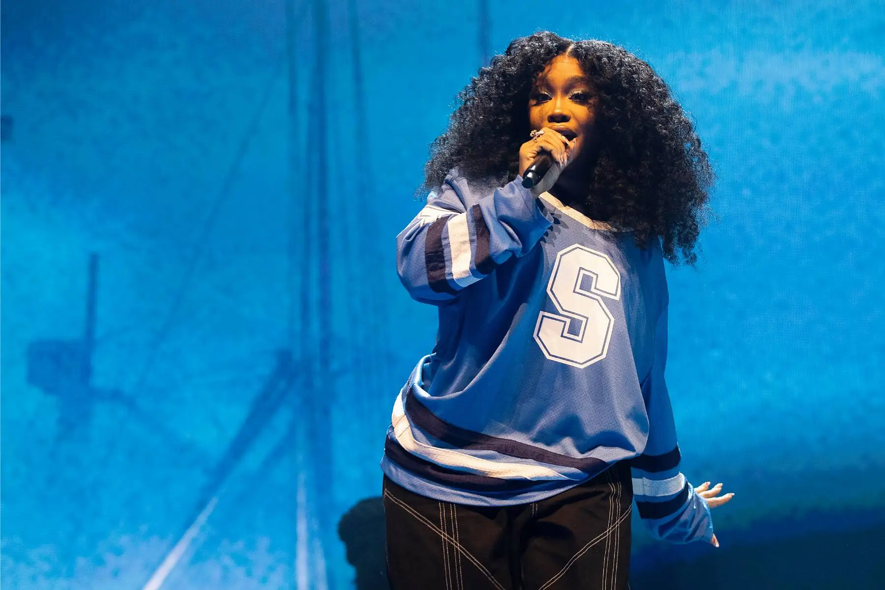 SZA performing live on stage, representing her gradual rise to the top of contemporary R&B