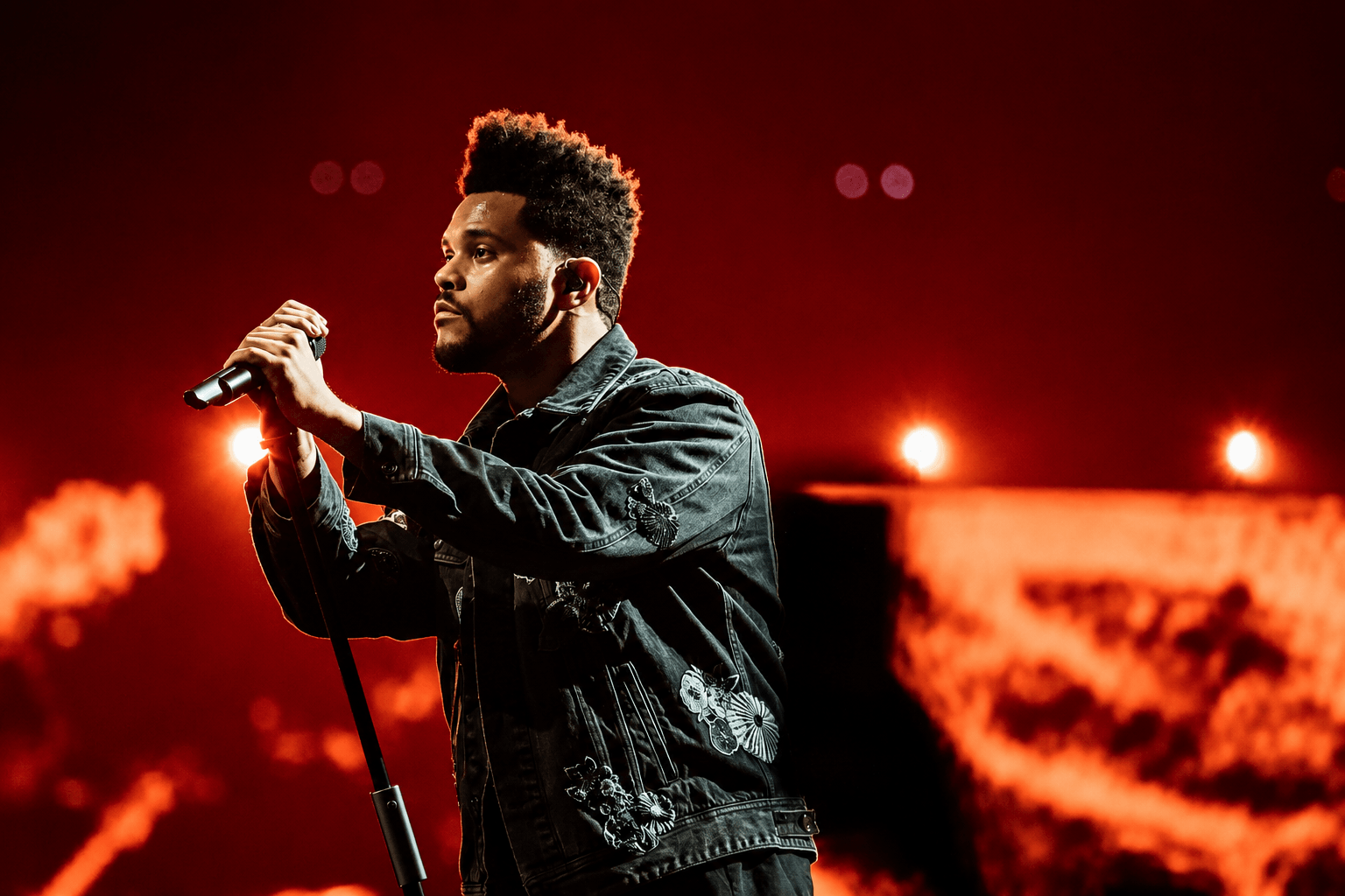 The Weeknd performing on a large stadium stage, representing his evolution from mixtapes to arena-level pop stardom